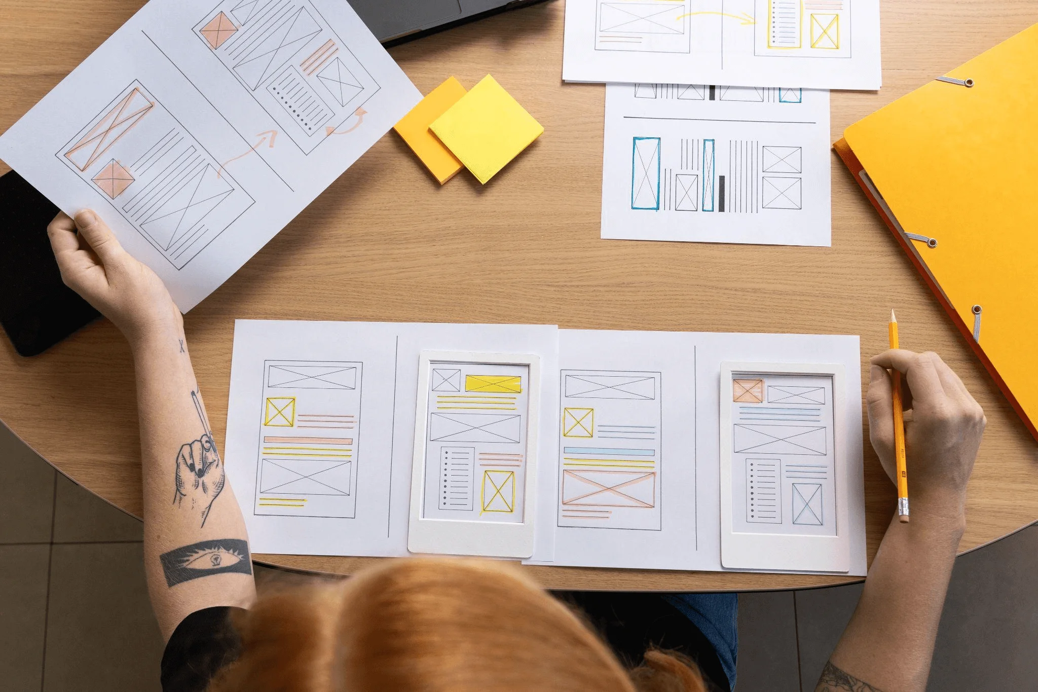 A person taking notes in the process of creating a wireframe, a major step in designing a website layout. 